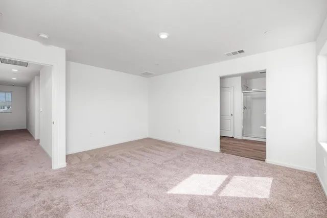 an empty room with closet and windows