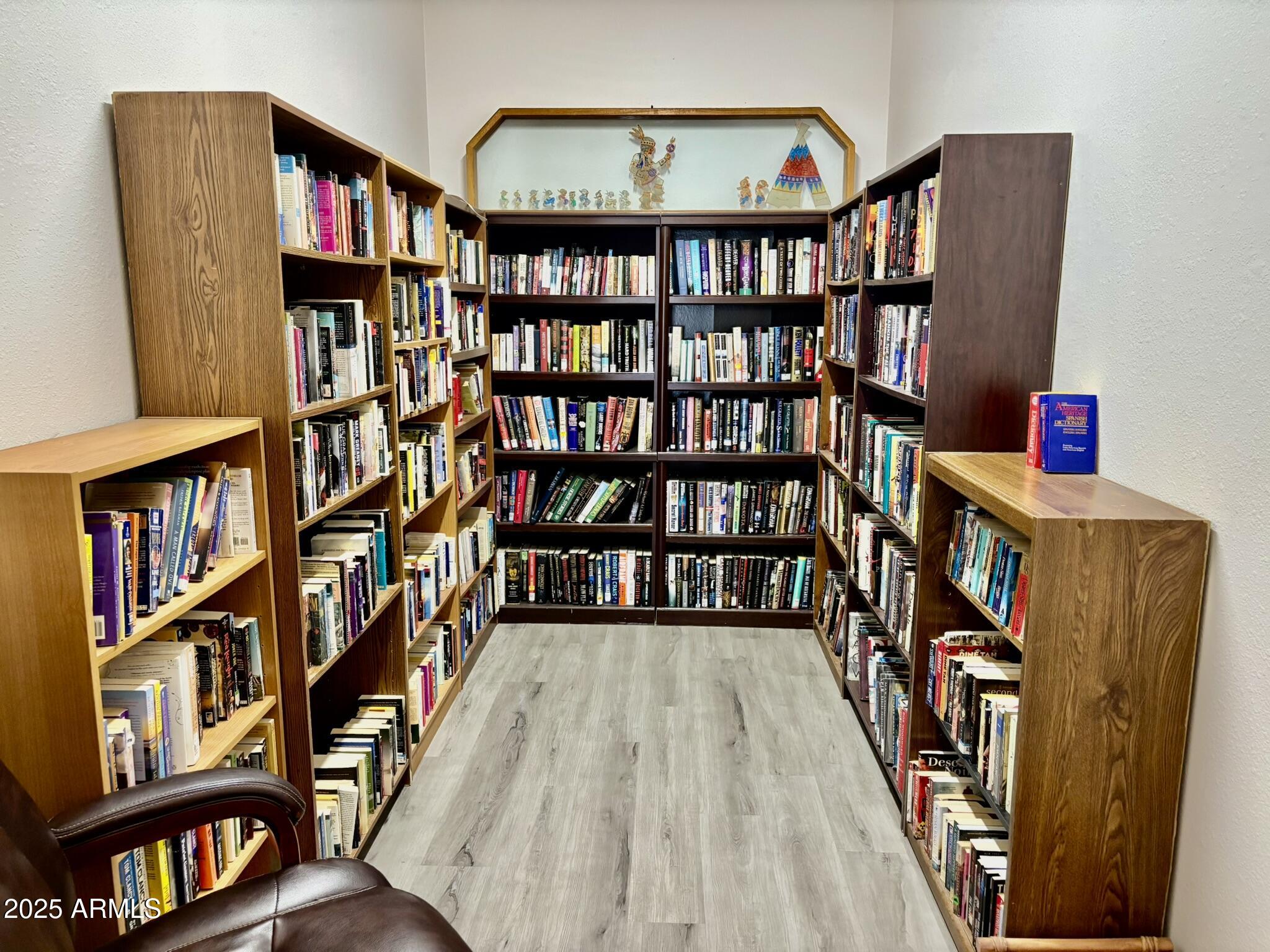 1050 East Broadway Avenue, Unit 44 Apache Junction, AZ 85119 - Photo 32 of 40 a wooden floor in a living room with a book shelf