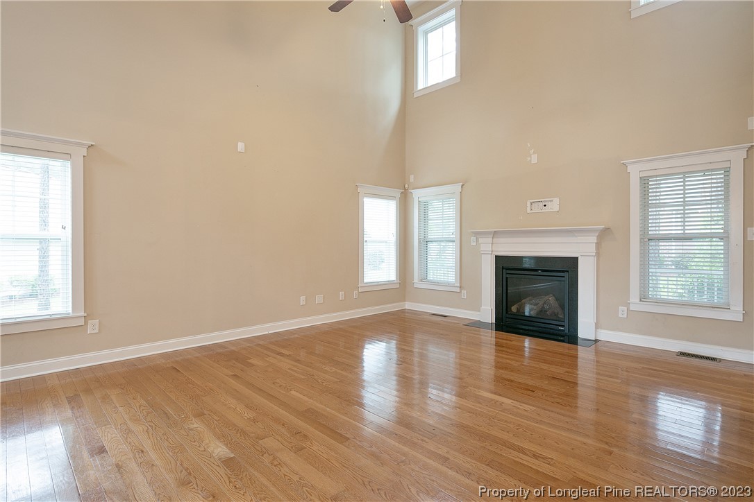32 Shellnut Circle Spring Lake, NC 28390 - Photo 13 of 50 an empty room with wooden floor fireplace and windows