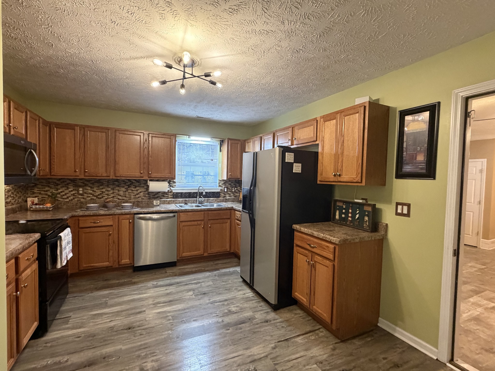 2938 Ridgewood Drive Christiana, TN 37037 - Photo 14 of 66 a kitchen with stainless steel appliances granite countertop a refrigerator a sink dishwasher a stove with wooden cabinets and floor