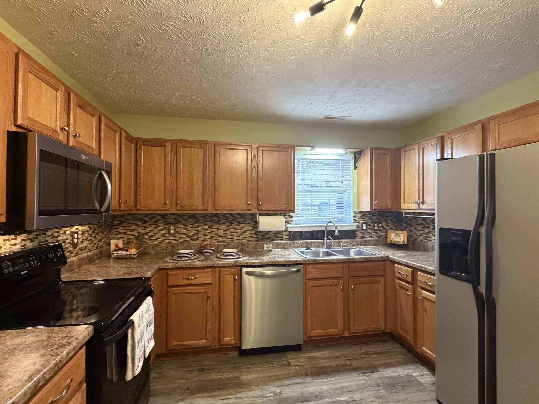 2938 Ridgewood Drive Christiana, TN 37037 - Photo 15 of 66 a kitchen with stainless steel appliances granite countertop a stove a sink dishwasher a refrigerator and cabinets with wooden floor