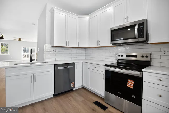 a kitchen with stainless steel appliances granite countertop a stove microwave and sink