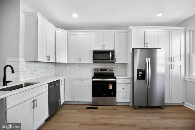 a kitchen with a refrigerator sink and cabinets