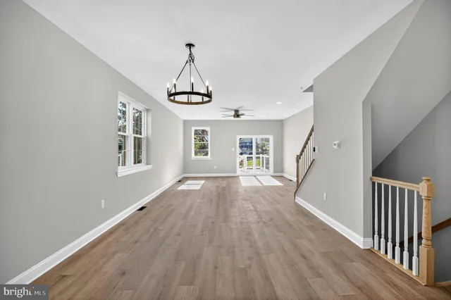 a view of empty room with wooden floor and window