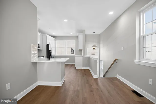 a view of a kitchen with wooden floor and electronic appliances