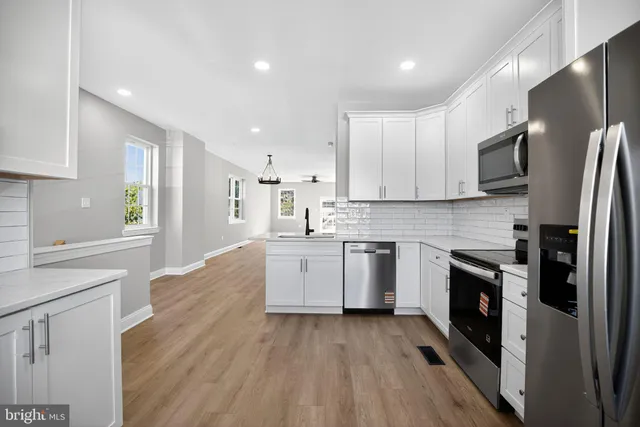 a kitchen with stainless steel appliances a refrigerator sink and stove top oven