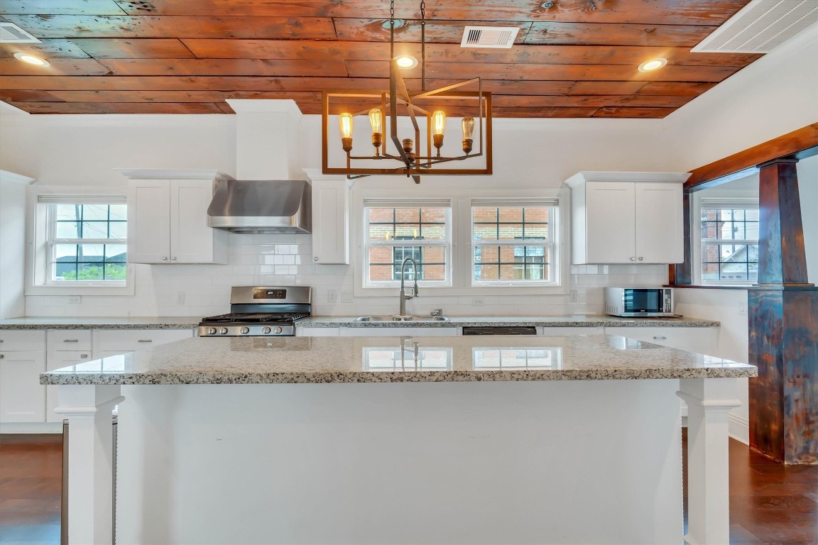 2405 Keene Street Houston, TX 77009 - Photo 13 of 45 a kitchen with granite countertop a sink a window stainless steel appliances and cabinets