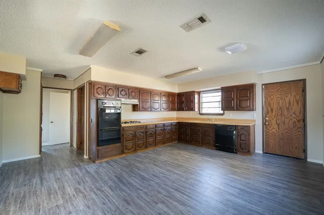 a kitchen with stainless steel appliances kitchen island wooden cabinets and wooden floor