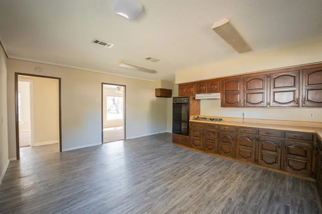 a spacious bathroom with stainless steel appliances granite countertop a sink and wooden floors