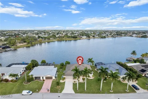 an aerial view of a house with outdoor space and lake view in back