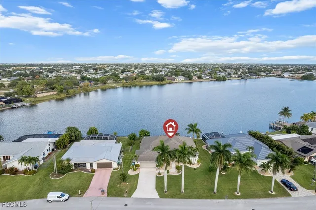 an aerial view of a house with outdoor space and lake view in back