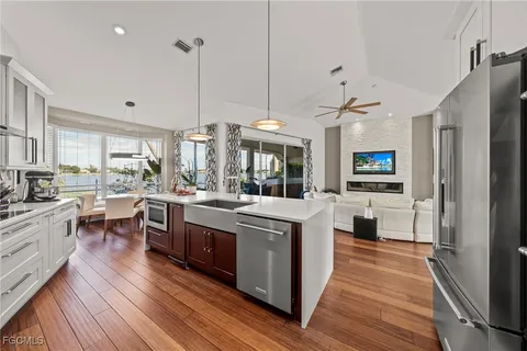 a kitchen with stainless steel appliances granite countertop wooden floors and white cabinets