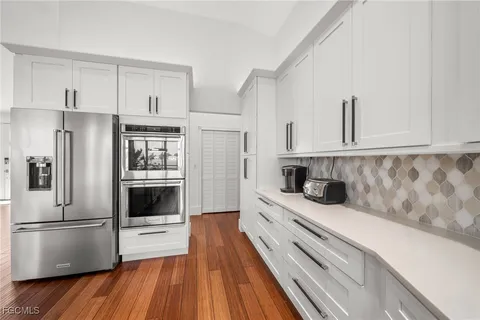 a kitchen with white cabinets and stainless steel appliances