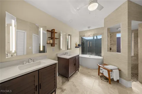 a large bathroom with a double vanity sink a large mirror and a bathtub