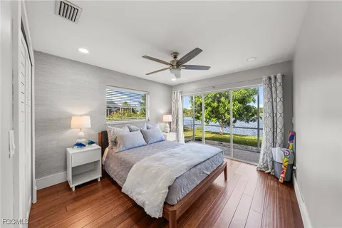 a bedroom with a bed and a large window with outer view