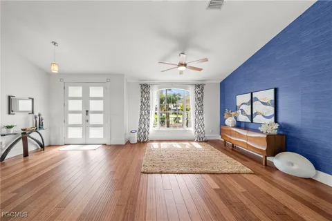 a spacious bedroom with a bed and wooden floor