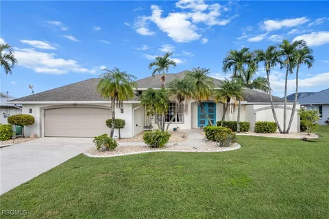 a view of a house with a yard and palm tree