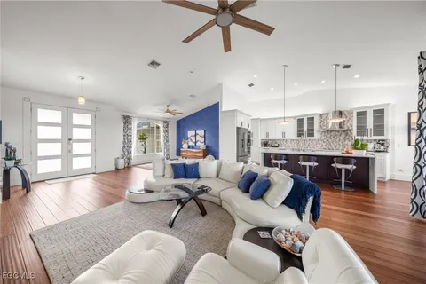 a living room with furniture kitchen view and a large window