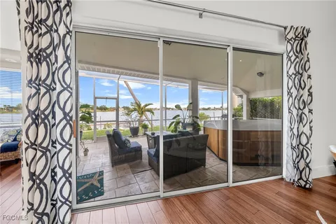 a view of a living room with a large window and wooden floor