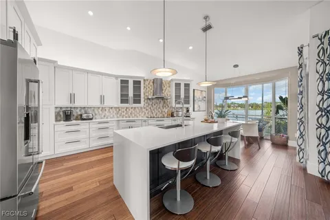 a kitchen with kitchen island granite countertop a island a stove a sink and a refrigerator