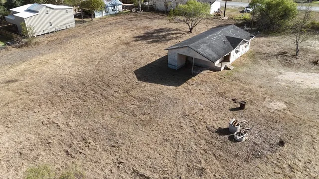 a view of a dry yard with wooden fence