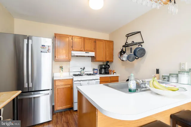 a kitchen with a refrigerator a stove and wooden floor