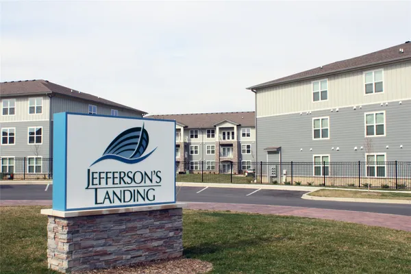 a view of sign board with buildings in the background