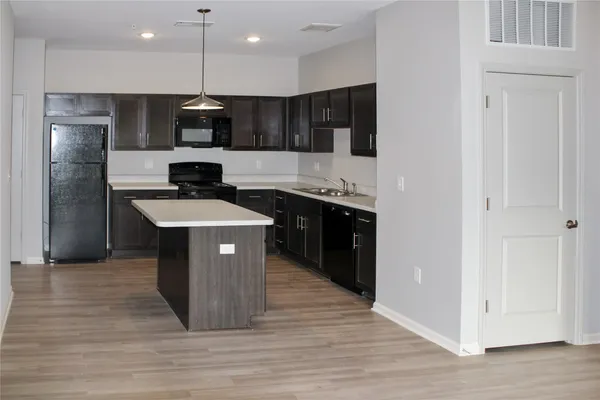 a kitchen with stainless steel appliances granite countertop a sink a stove and a refrigerator