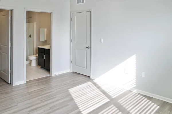 a view of a room with wooden floor and a bathroom