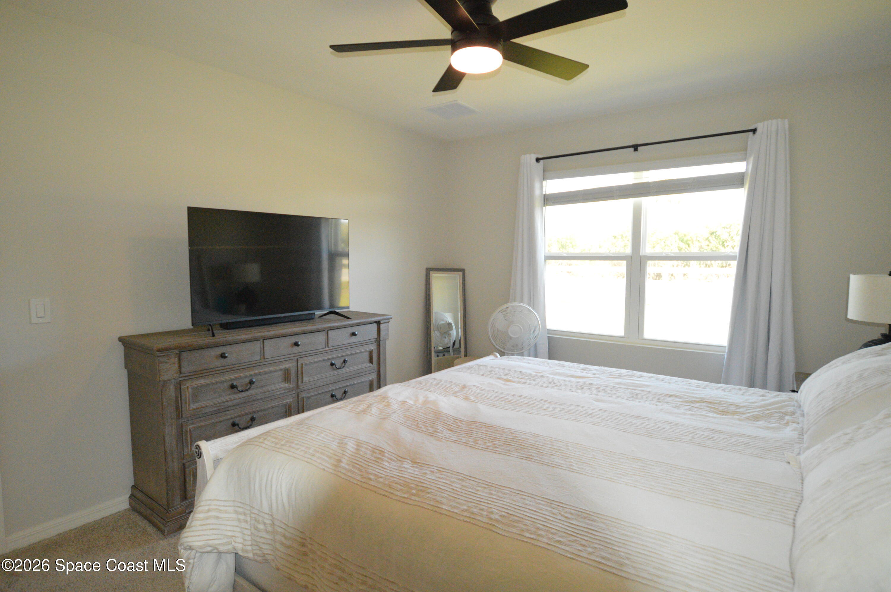 999 Trinity Street Rockledge, FL 32955 - Photo 15 of 20 a bedroom with a bed and a flat screen tv