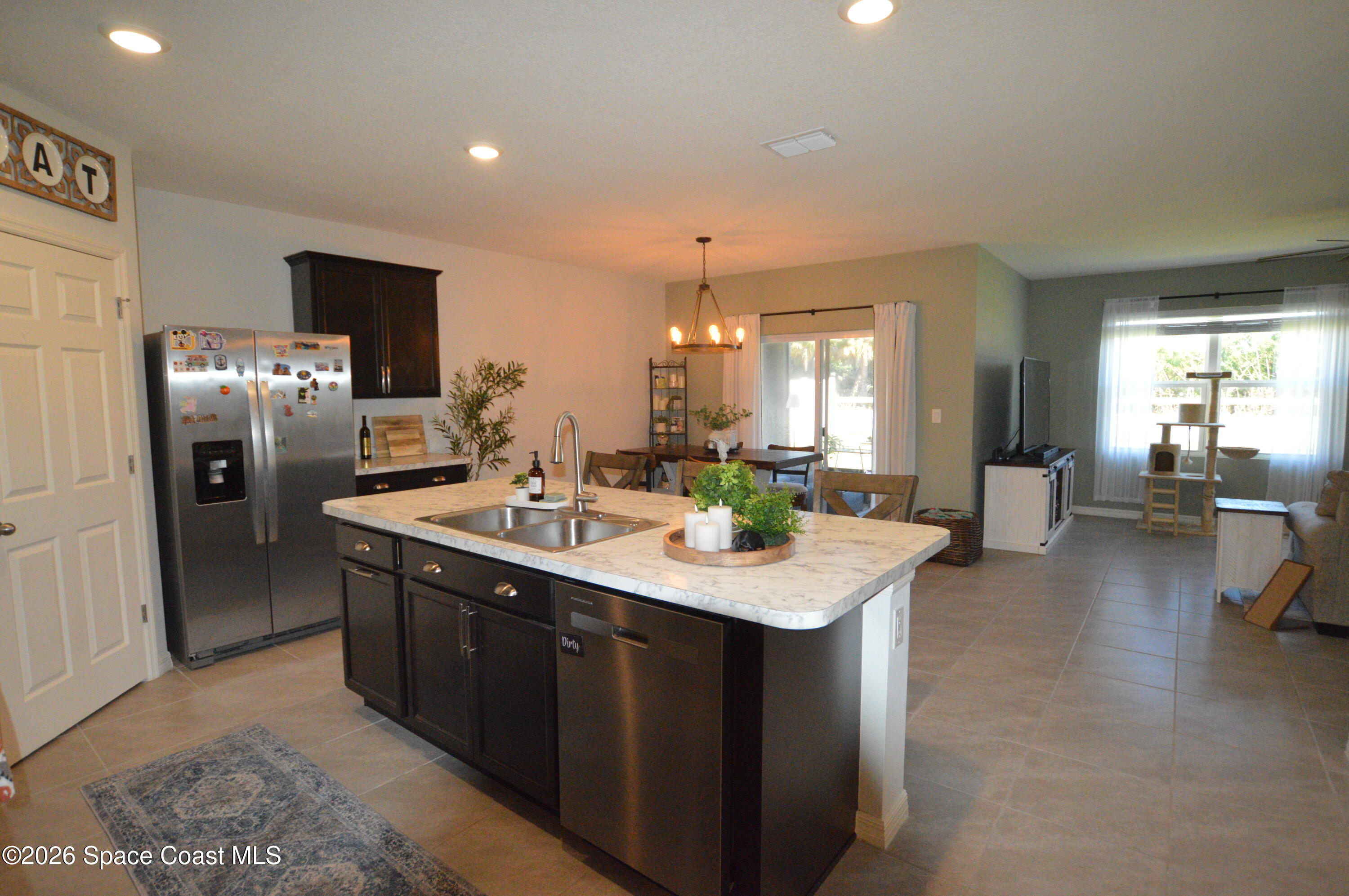 999 Trinity Street Rockledge, FL 32955 - Photo 6 of 20 a kitchen with stainless steel appliances granite countertop a sink stove and refrigerator