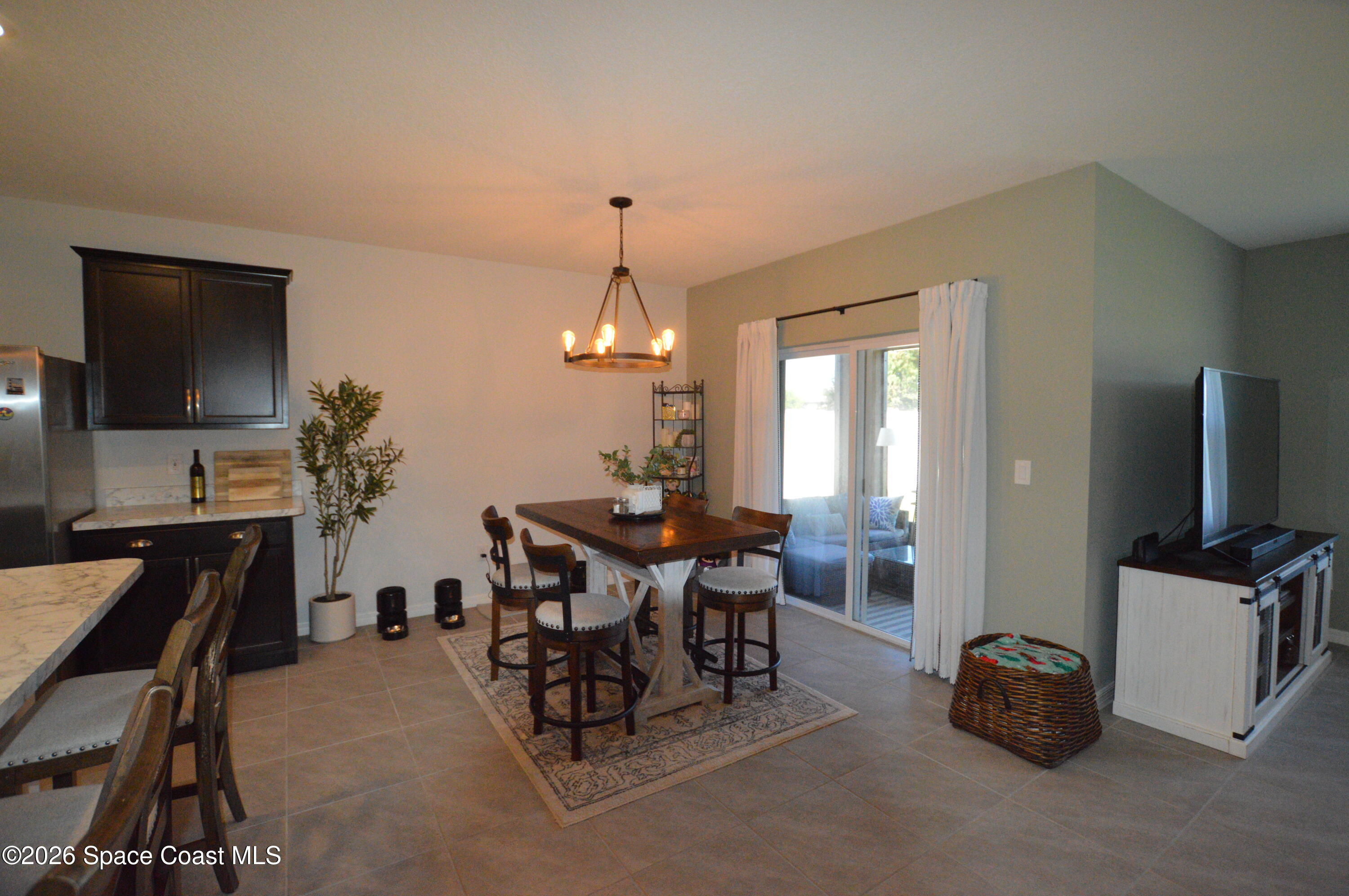 999 Trinity Street Rockledge, FL 32955 - Photo 7 of 20 a view of a dining room with furniture and a flat screen tv