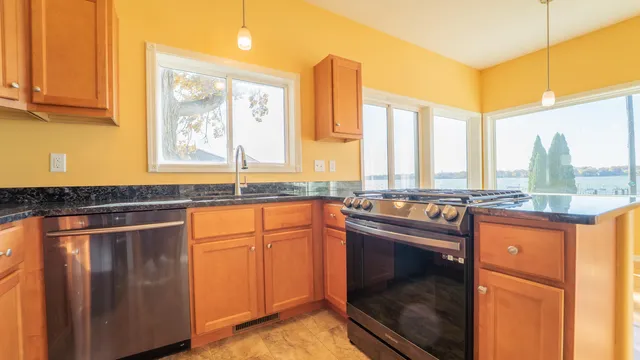 a kitchen with stainless steel appliances granite countertop a stove a sink and a microwave