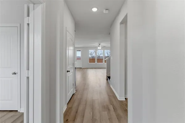 a view of a hallway with wooden floor and staircase