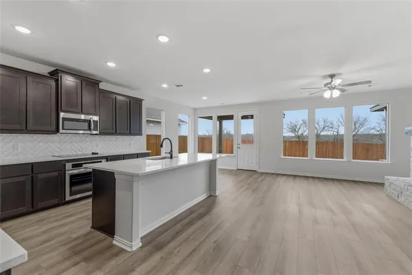 a large kitchen with stainless steel appliances and a stove top oven