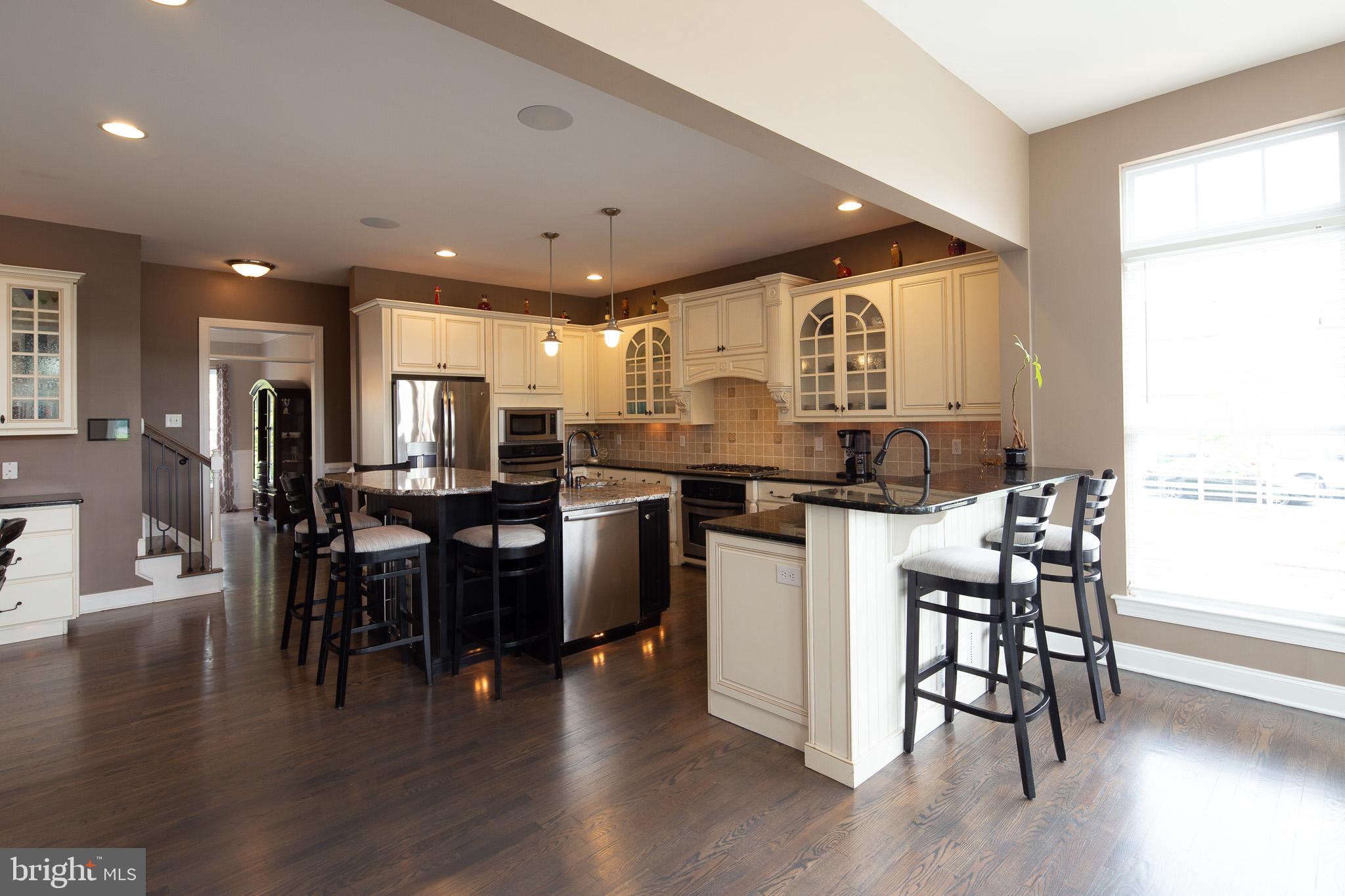 440 Spring Hollow Drive Middletown, DE 19709 - Photo 13 of 64 a kitchen with a table chairs wooden floors and a view of living room