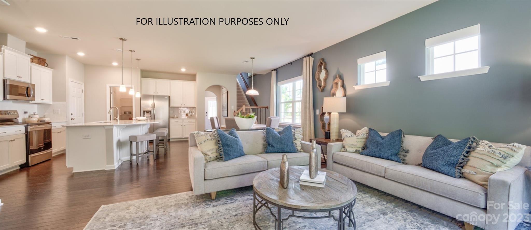 a living room with furniture kitchen view and a wooden floor
