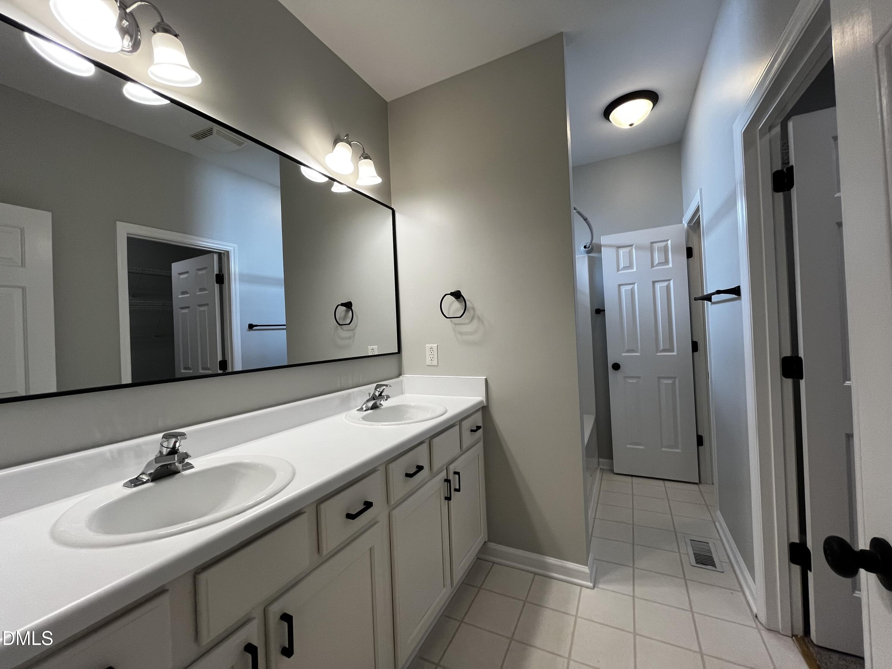 2816 Rainford Court Raleigh, NC 27603 - Photo 7 of 17 a bathroom with a double vanity sink mirror and shower