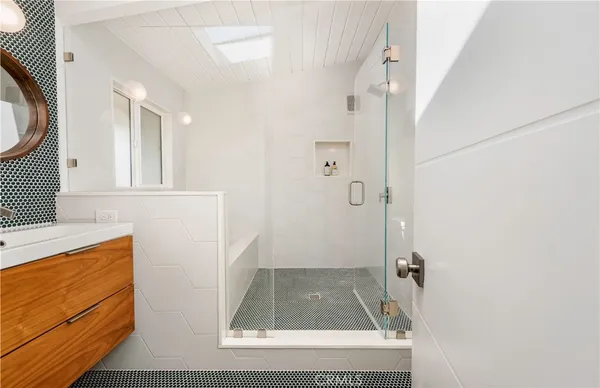 a bathroom with a sink a mirror and a shower
