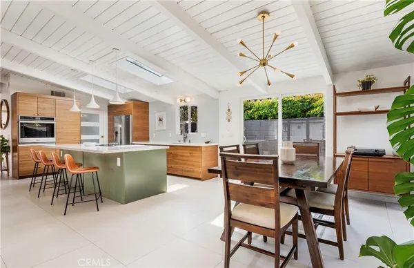 a dining room with furniture a floor to ceiling window and potted plants