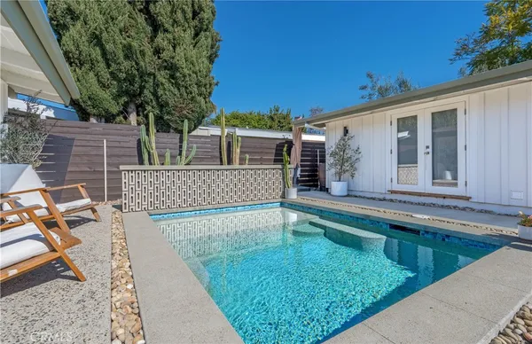 a view of a house with pool and chairs