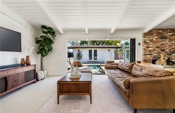 a living room with furniture flat screen tv and a potted plant