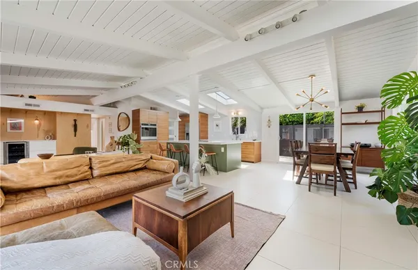 a living room with furniture kitchen view and a large window
