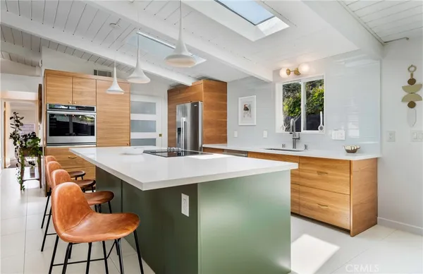 a kitchen with stainless steel appliances granite countertop a sink and a refrigerator