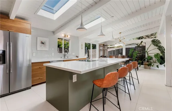a kitchen with stainless steel appliances kitchen island a table and chairs in it