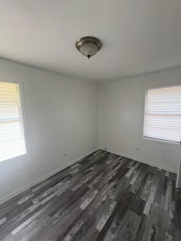 a view of a room with wooden floor and windows