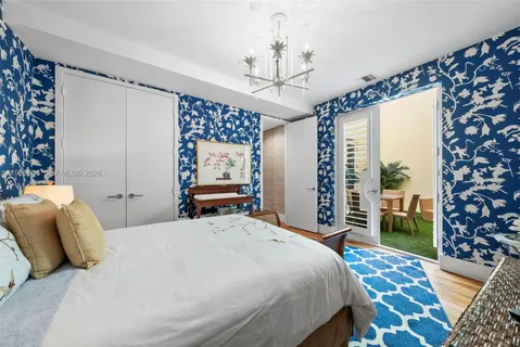 a bedroom with a large bed and a chandelier