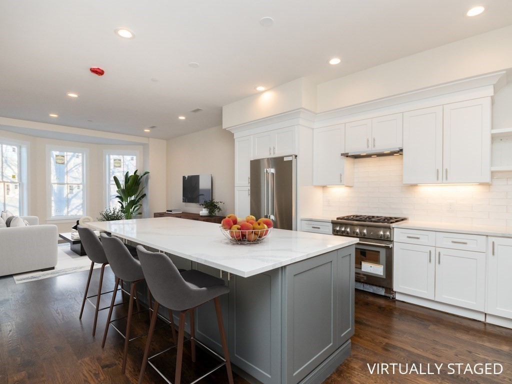 a kitchen with stainless steel appliances kitchen island granite countertop a stove a table and chairs