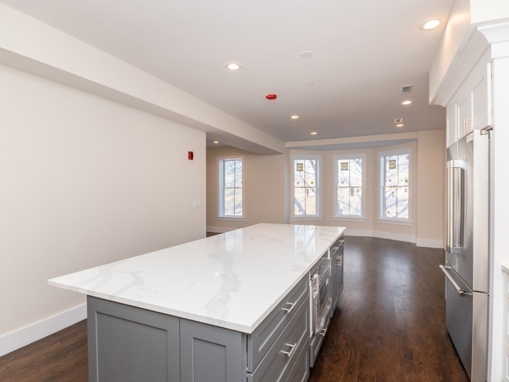 9 Monument Square, Unit 3 Boston, MA 02129 - Photo 3 of 14 a kitchen with a wooden floor and window