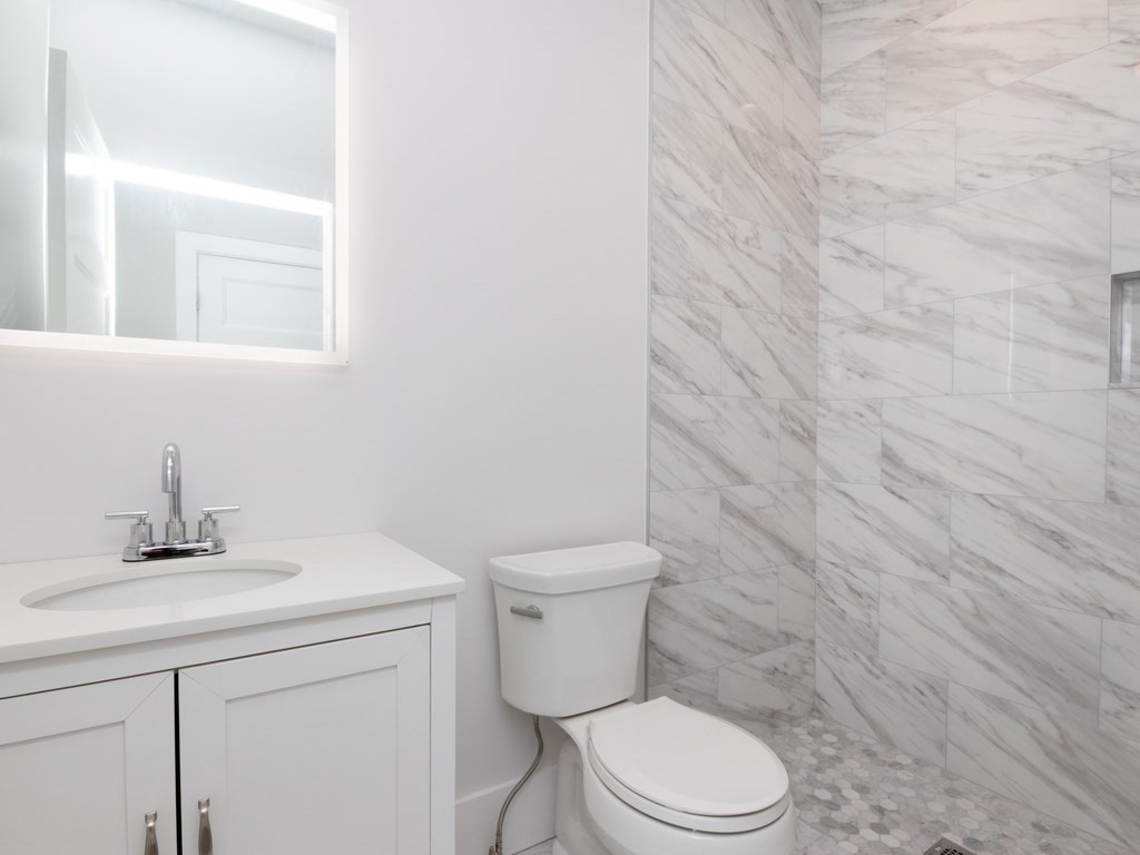 9 Monument Square, Unit 3 Boston, MA 02129 - Photo 10 of 14 a bathroom with a toilet sink vanity and mirror